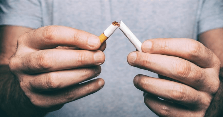 A person breaking a cigarette in half.